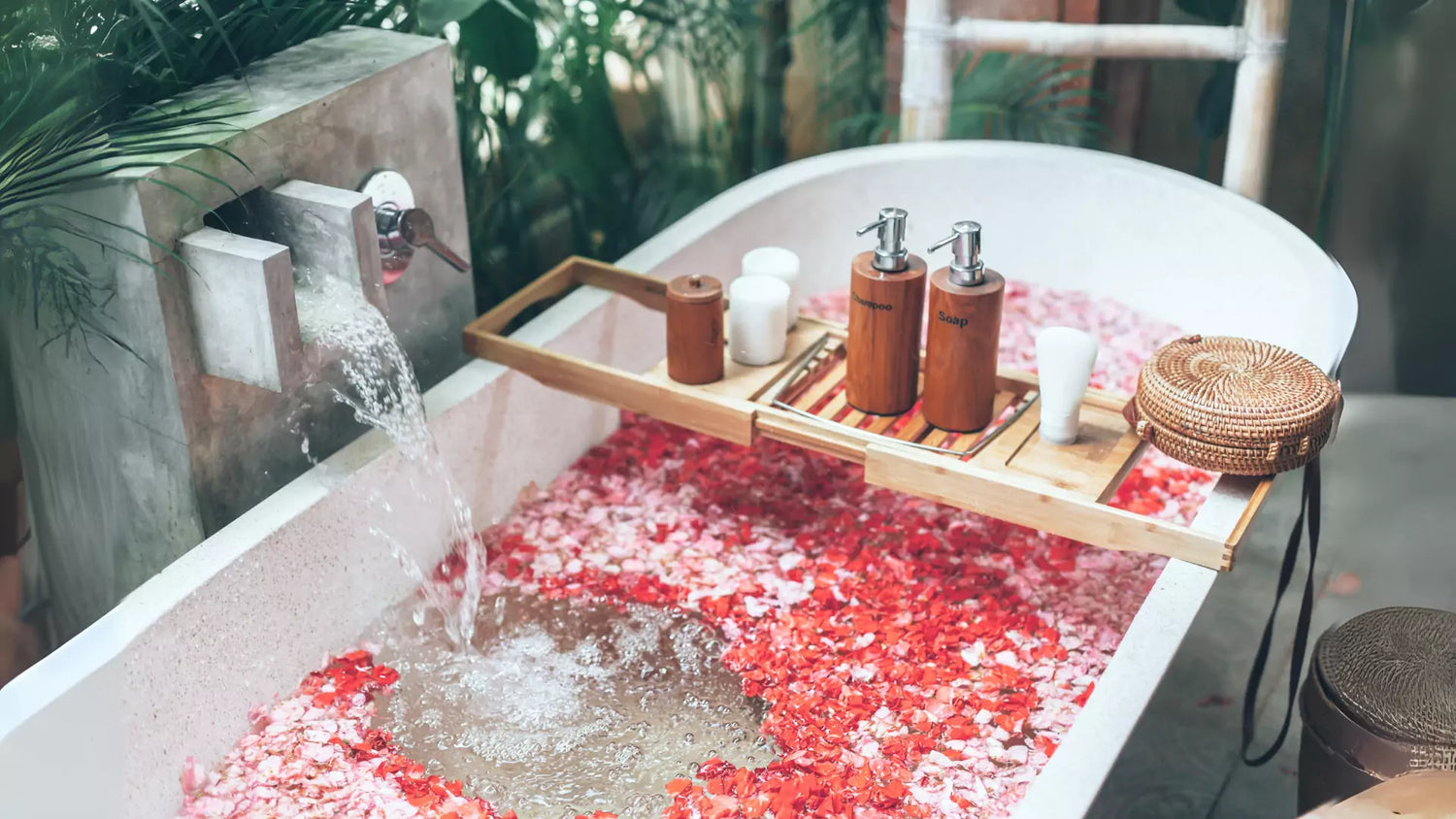 a bathtub filled with rose petals and water having Sweorn Bath and Beauty Products